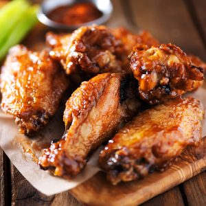 Chicken wings on a plate with a side of sauce