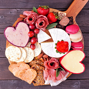 Charcuterie board with heart-shaped meats and cheese and crackers